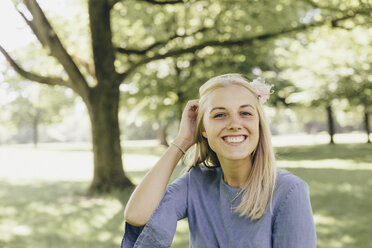 Portrait of happy young woman in a park - KMKF00278