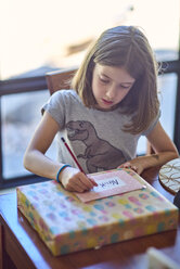 Girl writing gift card at table - BEF00167