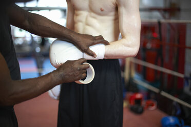 Trainer hilft Boxer beim Anziehen der Handschuhe, Mittelteil - CUF22148