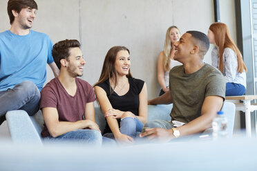 Gruppe von jungen männlichen und weiblichen Studenten, die auf einem Sofa sitzen und sich in einer Hochschule unterhalten - CUF22172