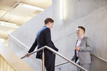 Two businessmen chatting on office stairway - CUF22240