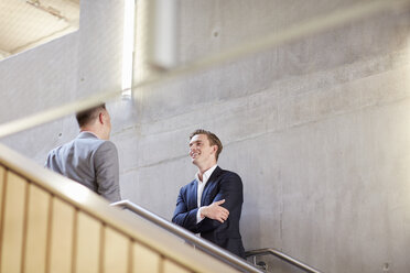 Two businessmen talking on office stairway - CUF22241