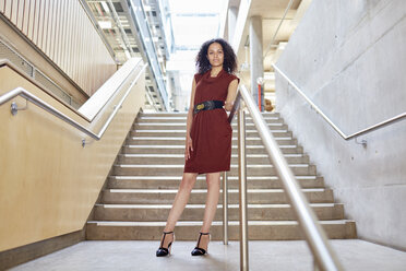 Porträt einer jungen Geschäftsfrau, die auf einer Bürotreppe steht - CUF22243