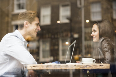 Young businessman and woman with laptop talking in cafe - CUF22257