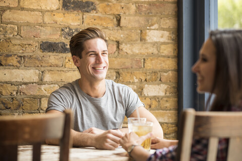 Junges Paar lachend und redend in einer Bar, lizenzfreies Stockfoto