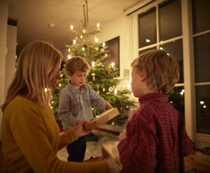 Mother and sons sitting at home at Christmas, exchanging gifts - CUF22298