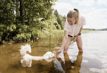 Frau mit Coton de tulear Hund im See, Orivesi, Finnland - CUF22371