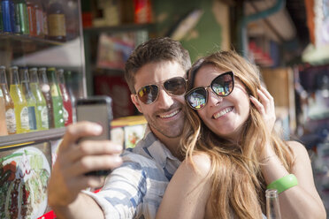 Couple using smartphone to take selfie, Coney island, Brooklyn, New York, USA - ISF07956