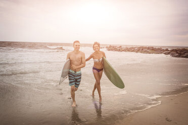 Junges Surferpaar mit Surfbrettern am Rockaway Beach, New York State, USA - ISF08078