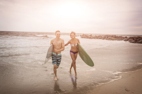 Junges Surferpaar mit Surfbrettern am Rockaway Beach, New York State, USA - ISF08078