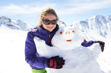 Porträt eines jugendlichen Mädchens, das einen Schneemann umarmt - ISF08109