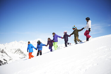 Group of children holding hands on snowy slope - ISF08110