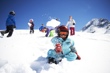Kleiner Junge wirft Schneeball, während Freunde hinter ihm spielen - ISF08114