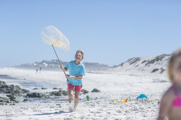 Junge läuft am Strand mit Fischernetz, Kapstadt, Südafrika - ISF08135