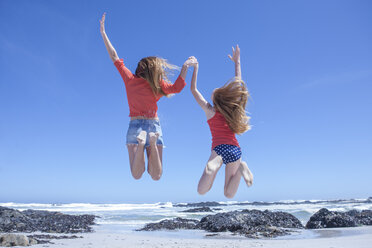 Mädchen und junge Frau springen mitten in der Luft am Strand, Kapstadt, Südafrika - ISF08136