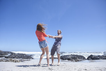 Junges Paar hält sich an den Händen und dreht sich am Strand, Kapstadt, Südafrika - ISF08139