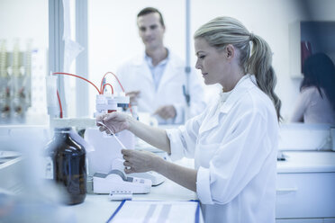 Mid adult woman looking at test sheet in laboratory - ISF08145