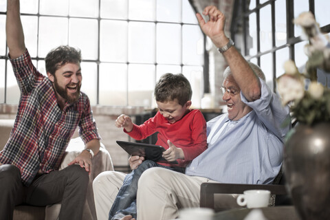 Drei-Generationen-Familie nutzt digitales Tablet zu Hause, lizenzfreies Stockfoto