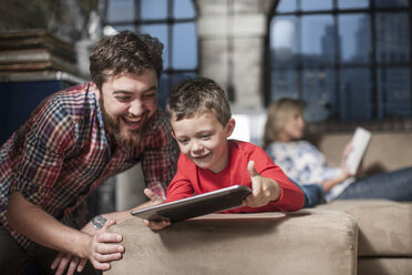 Vater und Sohn nutzen ein digitales Tablet zu Hause - ISF08178