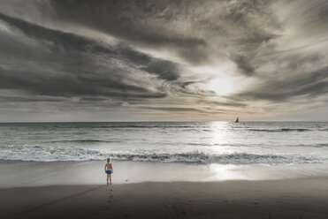 Junge mit Blick auf das Meer und den dramatischen Himmel von Venice Beach, Kalifornien, USA - ISF08184