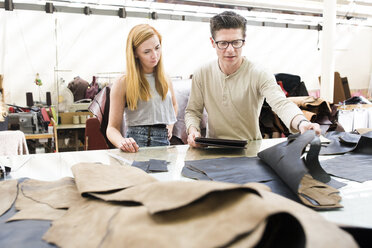 Männliche und weibliche Kollegen arbeiten gemeinsam in einer Lederjackenfabrik - CUF22555