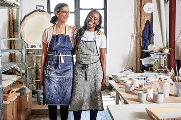 Potters in workshop wearing aprons smiling - ISF08234