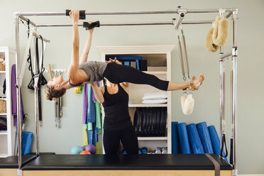 Seitenansicht einer Frau, die an einem Pilates-Reformer hängt - ISF08278