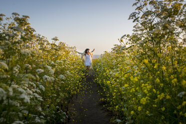 Frau geht durch ein Feld mit Wildblumen - ISF08288