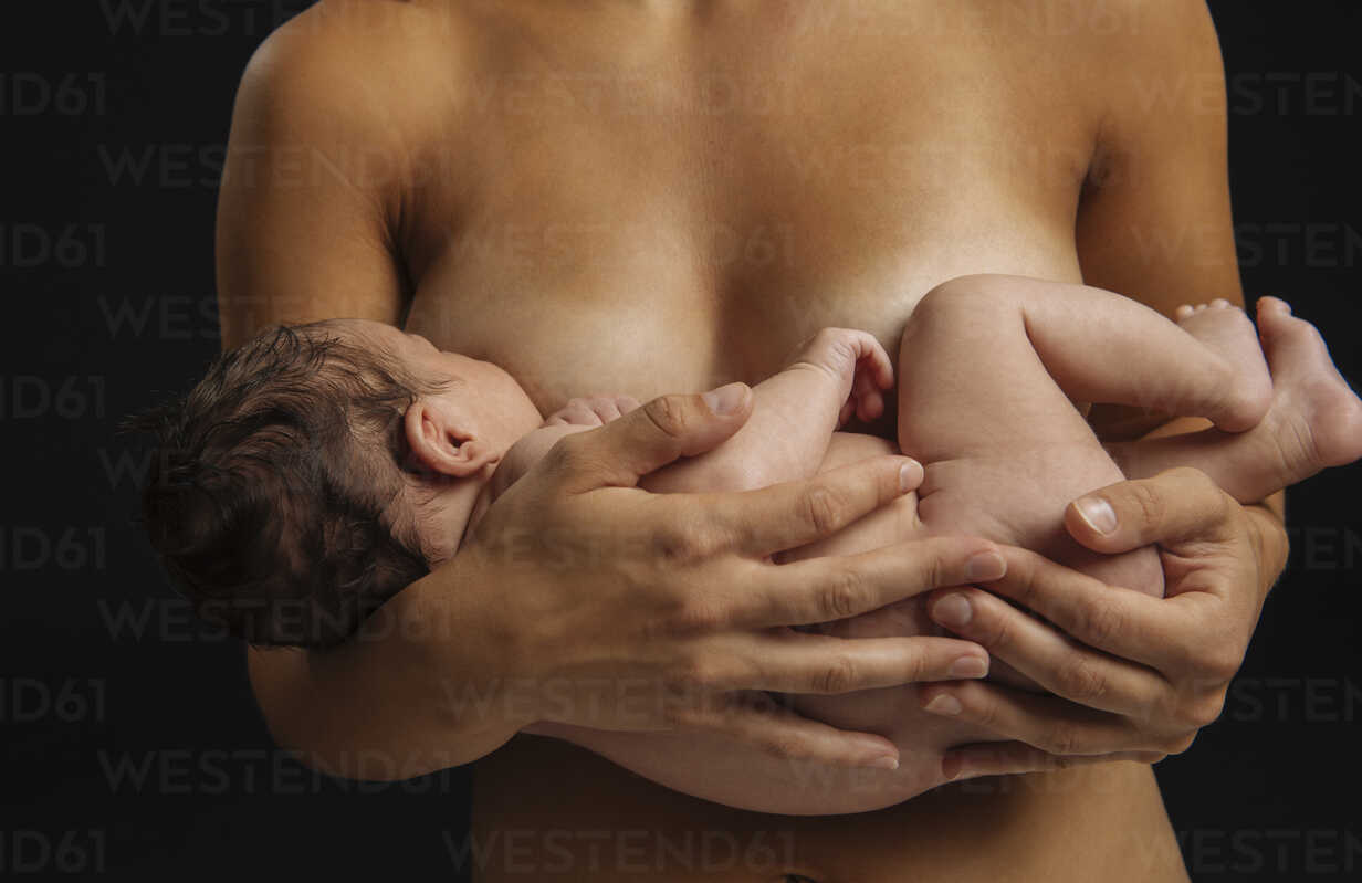 Naked woman cradling baby stock photo