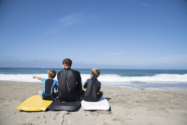 Rückansicht eines Mannes und zweier Söhne, die auf Bodyboards sitzen, Laguna Beach, Kalifornien, USA - ISF08399