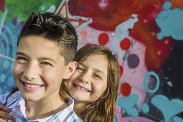 Porträt eines Jungen und seiner Schwester vor einer Wandmalerei in einem Vergnügungspark - ISF08419