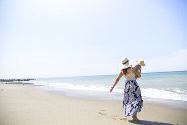 Rear view of mother carrying baby son on beach, Malibu, California, USA - ISF08429