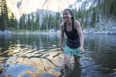 Young woman wading through lake, The Enchantments, Alpine Lakes Wilderness, Washington, USA - ISF08437