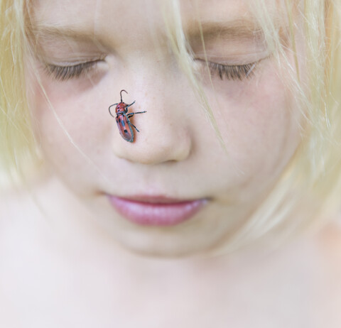 Junge mit Insekt auf der Nase, lizenzfreies Stockfoto
