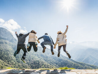 Group of people jumping in air, rear view, Sequoia National Park, California, USA - ISF08595