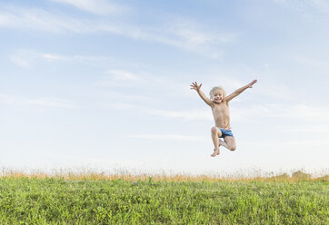 Junge im Feld, der in der Luft springt - ISF08620