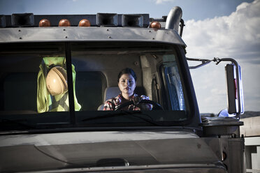 Porträt eines weiblichen Fahrers, der einen Lastwagen einer Recyclinganlage fährt - ISF08667