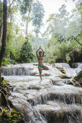 Frau auf einem Bein stehend, in Baumhaltung, im Kuang Si-Wasserfall, Luang Prabang, Laos - ISF08683