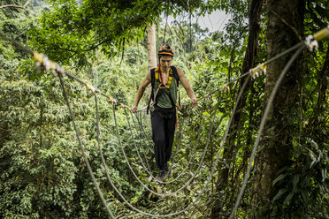 Mann überquert Seilbrücke im Wald, Ban Nongluang, Provinz Champassak, Paksong, Laos - ISF08692