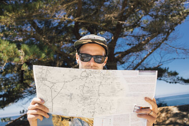 Man reading map at coast, Big Sur, California, USA - ISF08726