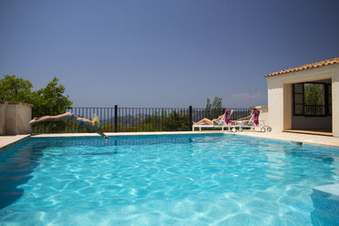 Junge Frau taucht in den Swimmingpool eines Boutique-Hotels, Mallorca, Spanien - CUF22666