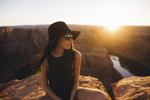 Frau entspannt und genießt die Aussicht, Horseshoe Bend, Page, Arizona, USA, lizenzfreies Stockfoto