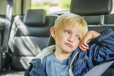 Young boy sitting in back of vehicle, bored expression - ISF08787