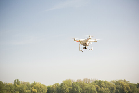 Drohne fliegt am blauen Himmel, lizenzfreies Stockfoto