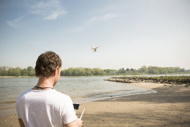 Mann fliegt Drohne an einem Fluss - ONF01145