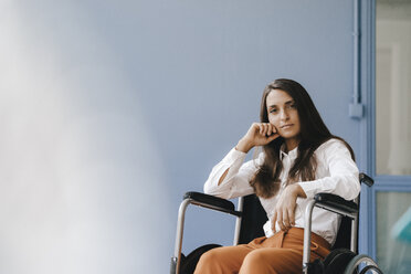 Young handicapped woman sitting in wheelchair, looking worried - KNSF03909