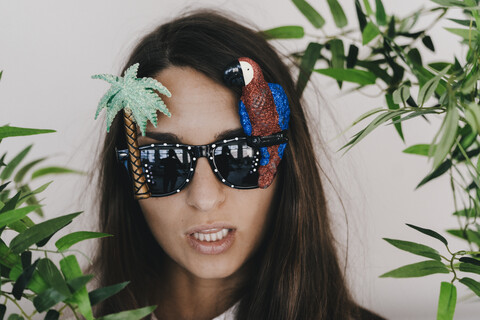 Junge Frau mit exotischer Sonnenbrille, Palme und Papagei, lizenzfreies Stockfoto