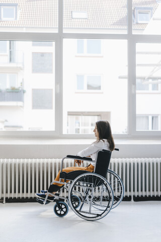 Junge behinderte Frau im Rollstuhl sitzend, lizenzfreies Stockfoto