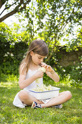 Kleines Mädchen sitzt auf einer Wiese im Garten mit einer Schale gepflückter Holunderblüten - LVF07022