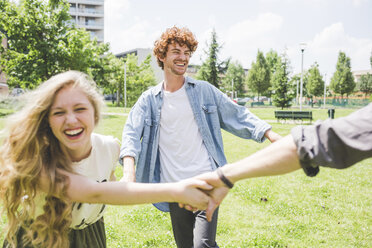 Friends circle dancing in park - CUF22820